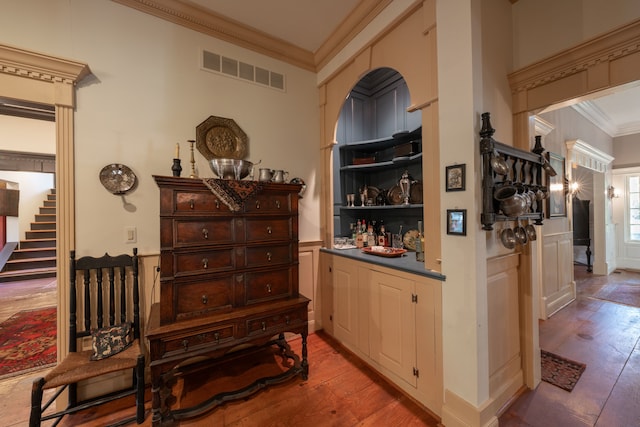 bar with hardwood / wood-style floors and ornamental molding