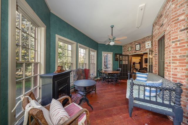 sunroom / solarium featuring ceiling fan and a baseboard heating unit