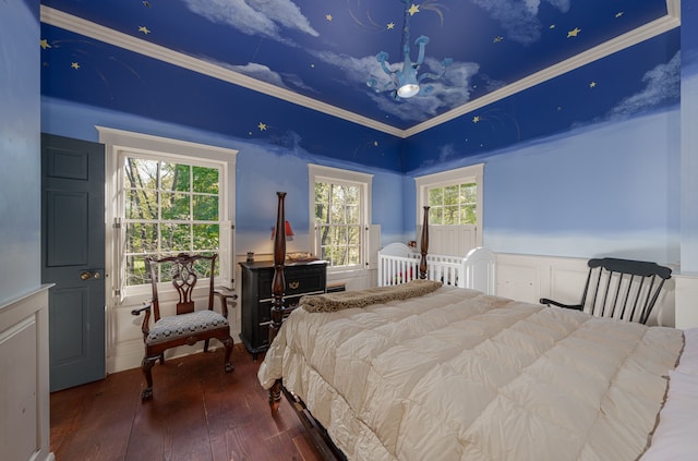 bedroom featuring multiple windows, hardwood / wood-style floors, and ornamental molding