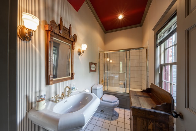 full bathroom featuring sink, tile patterned floors, crown molding, bath / shower combo with glass door, and toilet