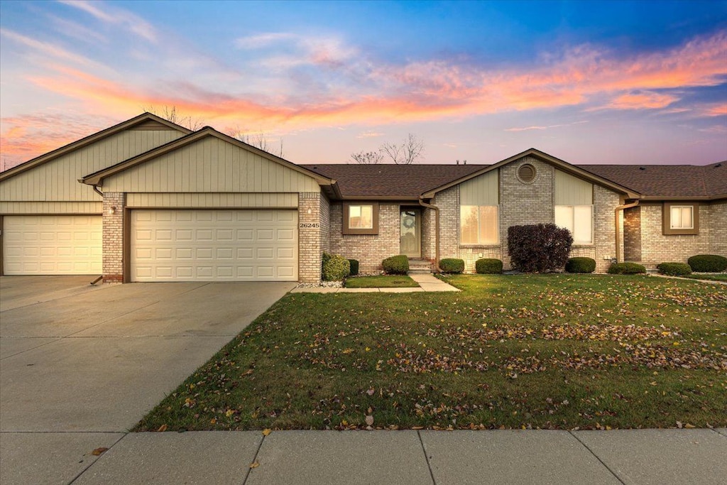 ranch-style home featuring a yard and a garage