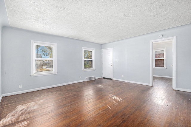 unfurnished room with a textured ceiling and dark wood-type flooring