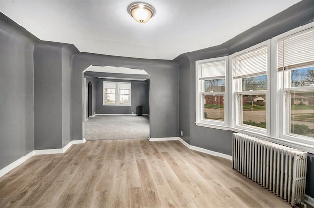 empty room with radiator and light wood-type flooring