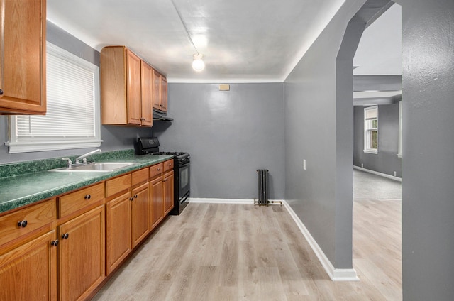 kitchen with a wealth of natural light, sink, black gas range oven, and light wood-type flooring