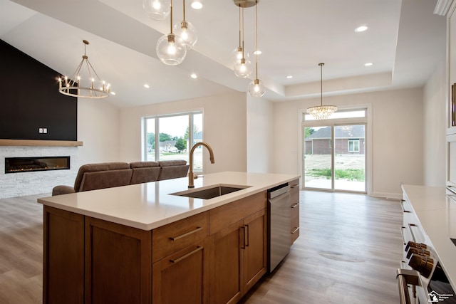 kitchen featuring decorative light fixtures, stainless steel dishwasher, and sink