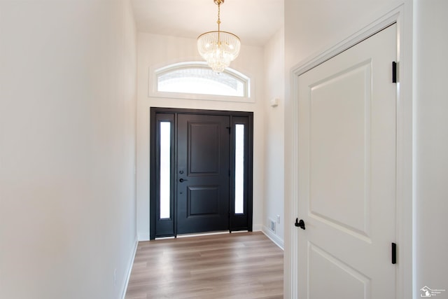 foyer entrance featuring light hardwood / wood-style floors and a notable chandelier