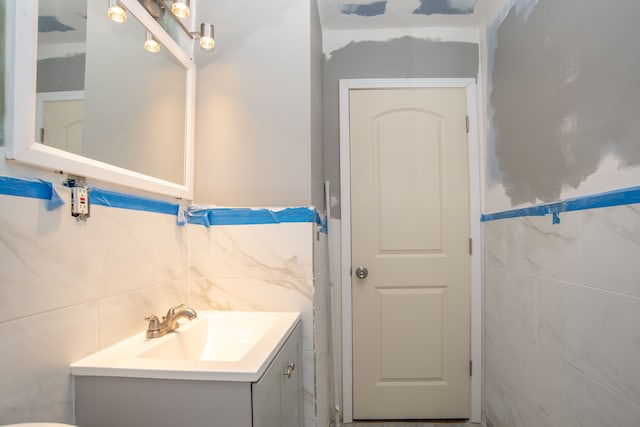 bathroom with vanity and tile walls