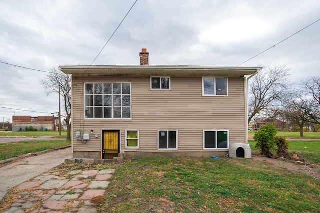 back of property featuring a lawn