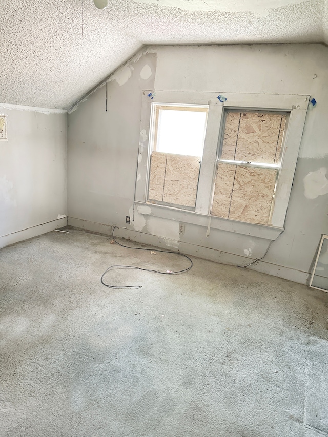 bonus room with carpet, a textured ceiling, and vaulted ceiling