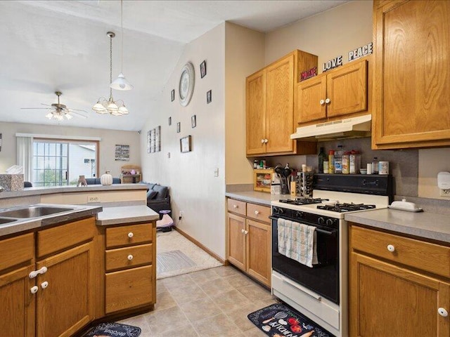 kitchen with white gas range, sink, pendant lighting, vaulted ceiling, and ceiling fan with notable chandelier