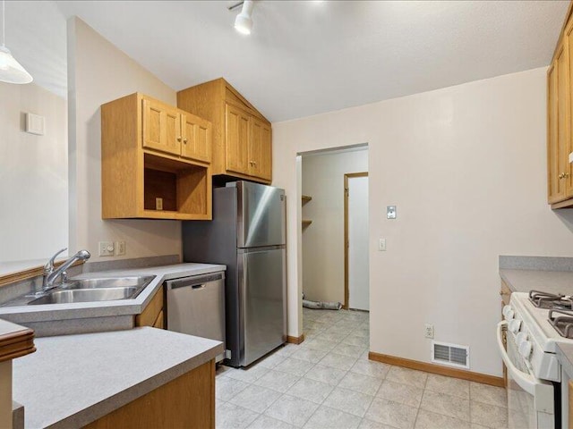 kitchen featuring sink, light brown cabinets, pendant lighting, lofted ceiling, and appliances with stainless steel finishes