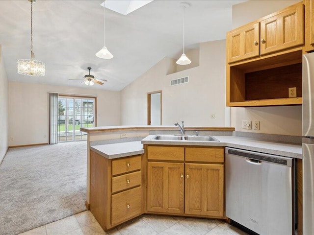 kitchen featuring pendant lighting, lofted ceiling with skylight, sink, and stainless steel appliances