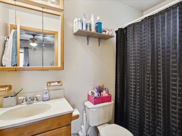 bathroom with vanity, ceiling fan, toilet, and curtained shower