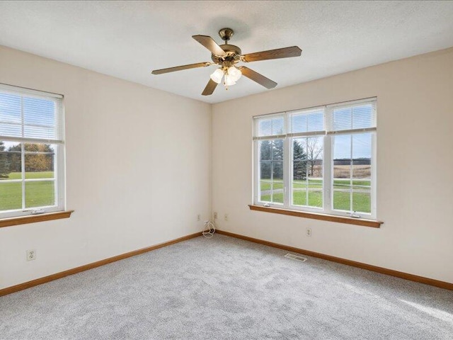 carpeted empty room featuring ceiling fan