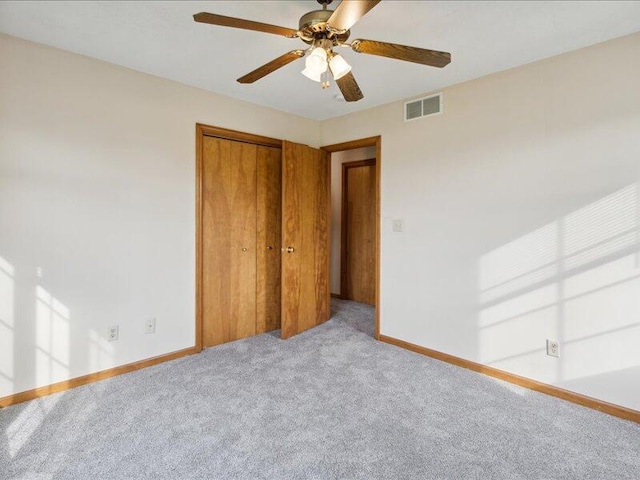 unfurnished bedroom featuring a closet, ceiling fan, and light colored carpet