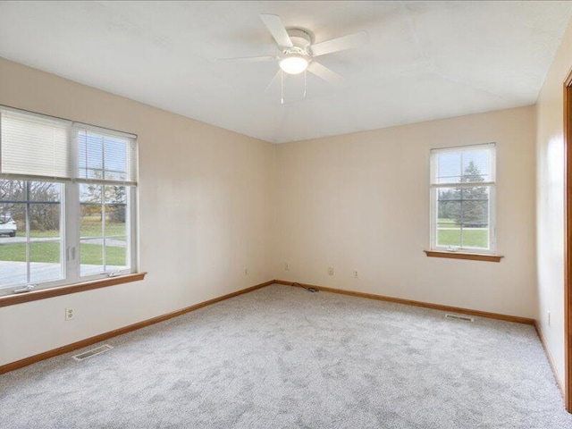 carpeted spare room featuring ceiling fan