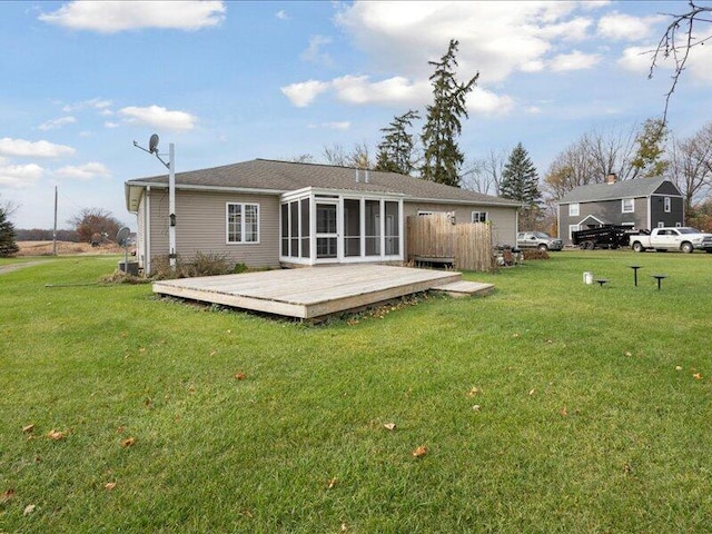 rear view of house featuring a lawn and a deck