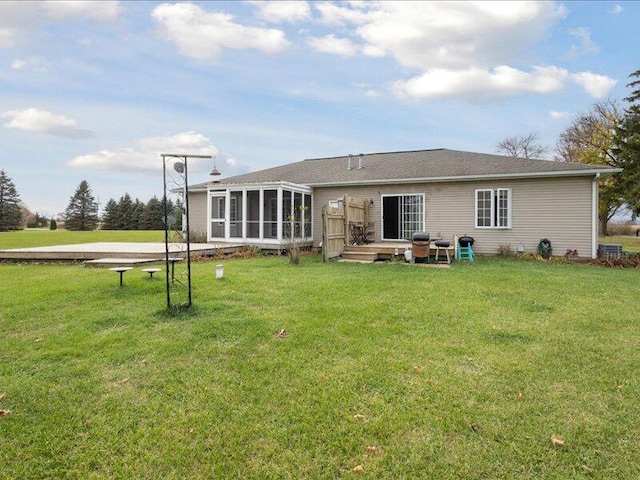 back of house with a lawn and a sunroom