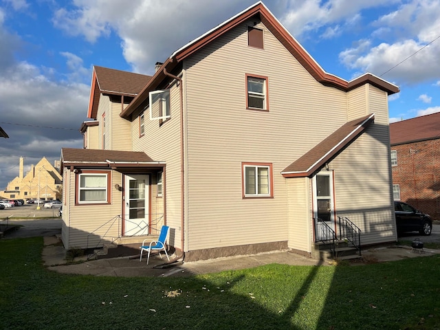 rear view of property featuring a lawn