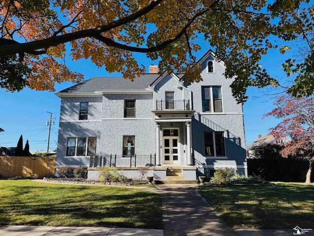 view of front of home featuring a balcony and a front yard