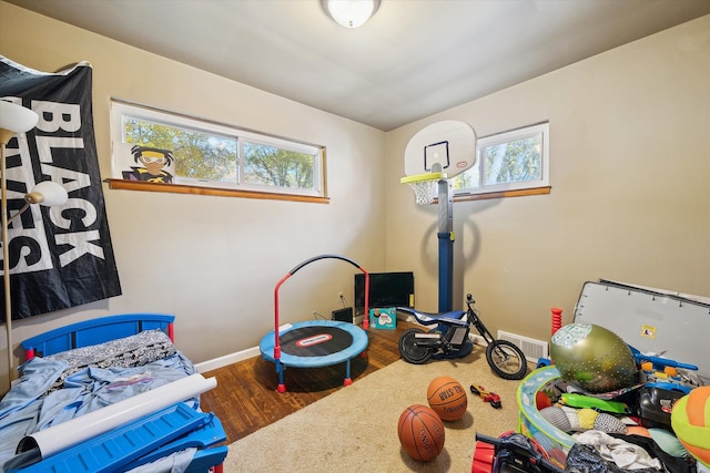 playroom featuring a healthy amount of sunlight and dark hardwood / wood-style flooring