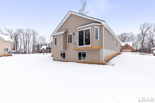 view of snow covered rear of property