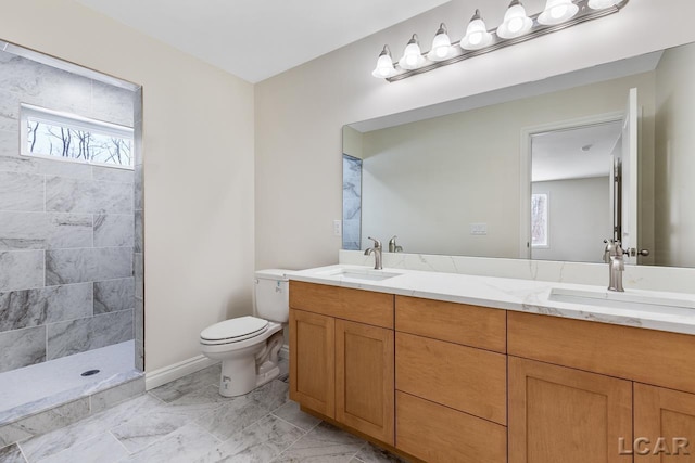 bathroom featuring toilet, vanity, and tiled shower