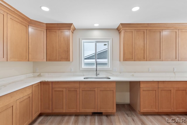 kitchen featuring light hardwood / wood-style flooring, light stone counters, and sink