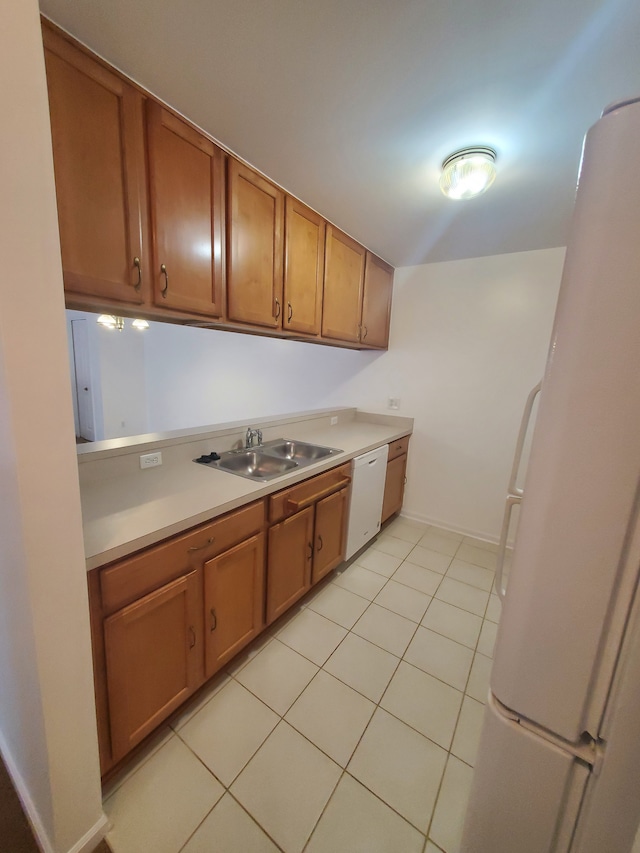 kitchen with sink, light tile patterned floors, and white appliances