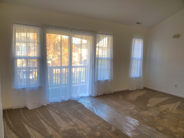 unfurnished room featuring carpet flooring and vaulted ceiling