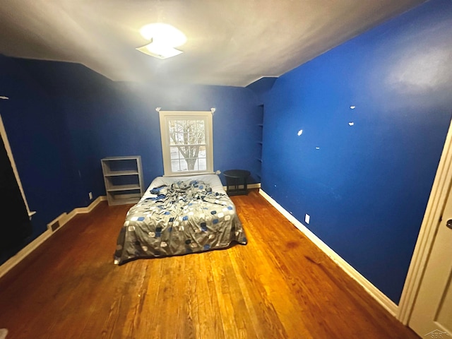 bedroom featuring vaulted ceiling and dark hardwood / wood-style floors