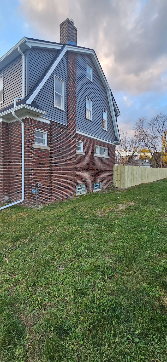 property exterior at dusk with a lawn