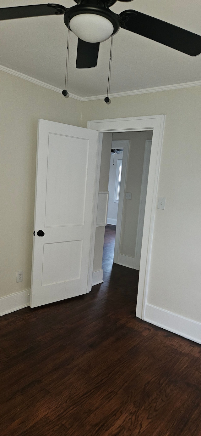 empty room with crown molding, ceiling fan, and dark hardwood / wood-style floors