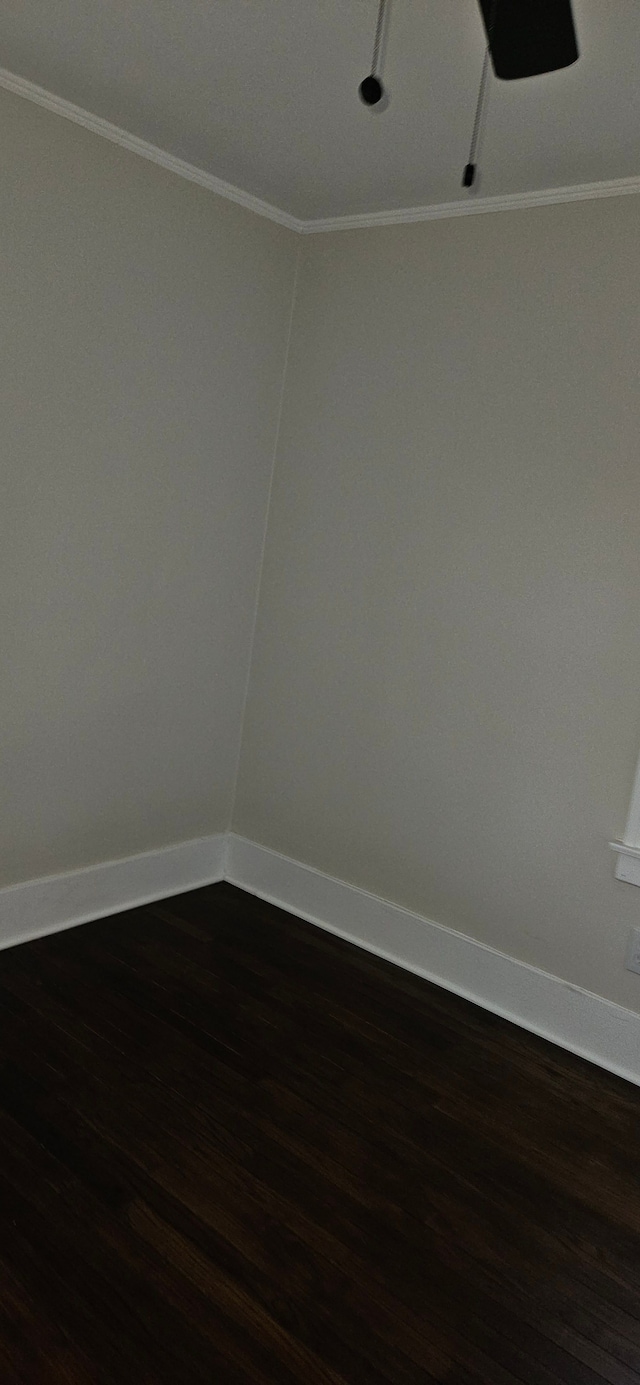 unfurnished room with dark hardwood / wood-style flooring and ornamental molding