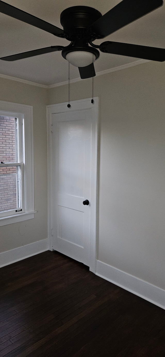 unfurnished room featuring ceiling fan, crown molding, and dark wood-type flooring