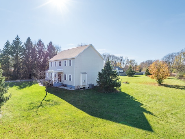 view of side of property with a lawn and central air condition unit