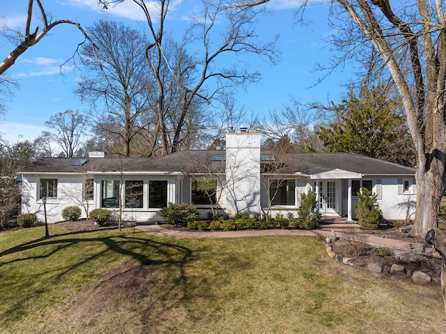 ranch-style home with a chimney and a front lawn