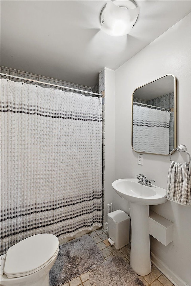 full bath with toilet, a shower with curtain, and tile patterned flooring