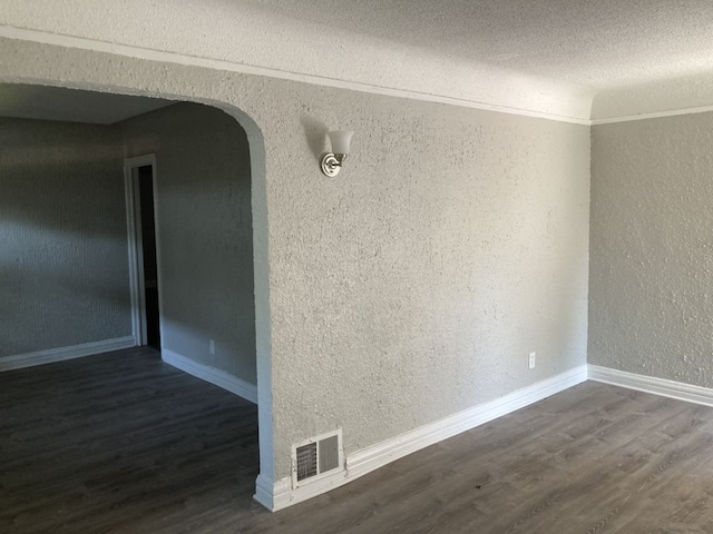 empty room featuring a textured ceiling and dark wood-type flooring