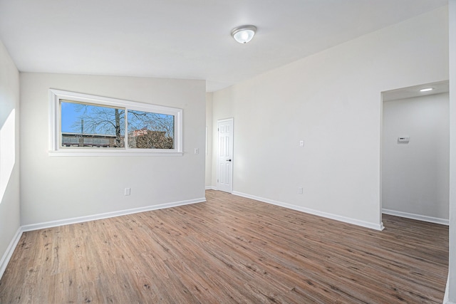 unfurnished room with wood-type flooring and lofted ceiling