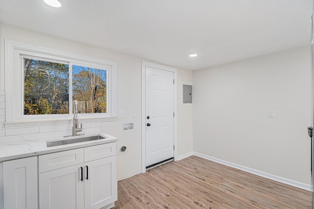 interior space featuring electric panel, sink, and light wood-type flooring