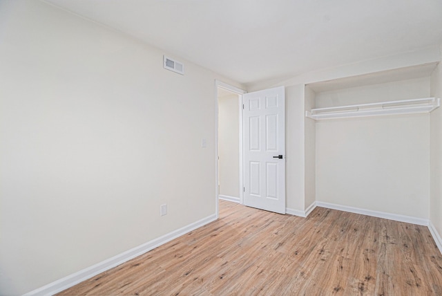 unfurnished bedroom with a closet and light hardwood / wood-style flooring