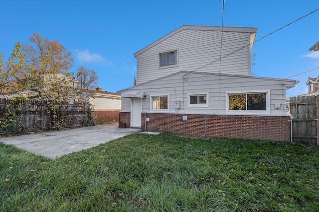 back of property with a lawn and a patio