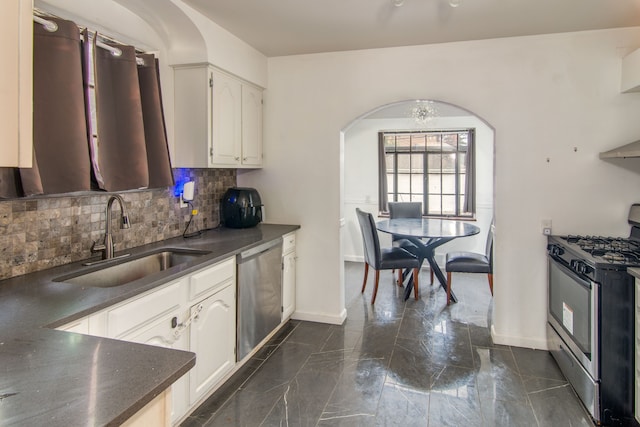 kitchen featuring sink, an inviting chandelier, tasteful backsplash, white cabinets, and appliances with stainless steel finishes