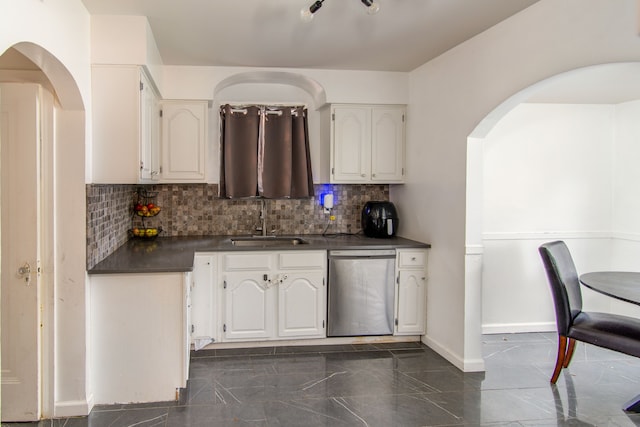 kitchen with decorative backsplash, white cabinetry, sink, and stainless steel dishwasher