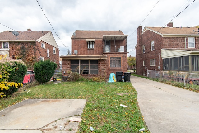 rear view of house with a sunroom and a yard