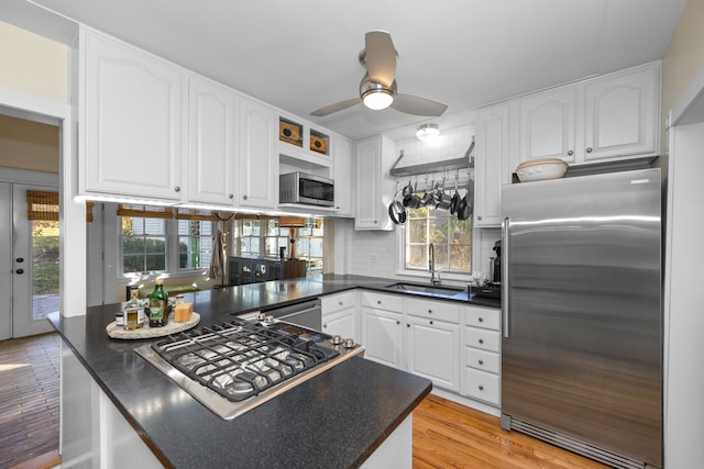 kitchen with white cabinets, sink, stainless steel appliances, and tasteful backsplash