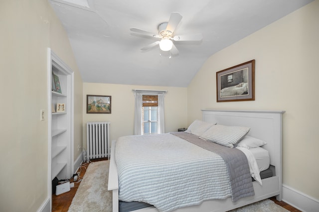 bedroom featuring hardwood / wood-style flooring, ceiling fan, radiator heating unit, and lofted ceiling