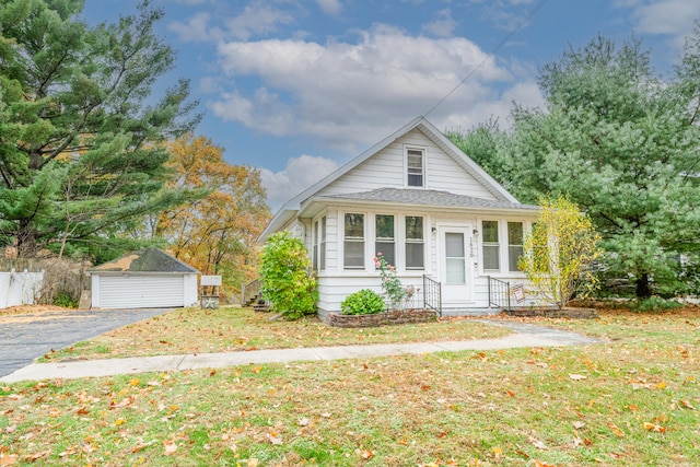 view of front of property featuring an outbuilding, a front lawn, and a garage