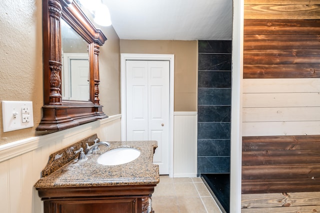 bathroom with tile patterned floors, vanity, and walk in shower